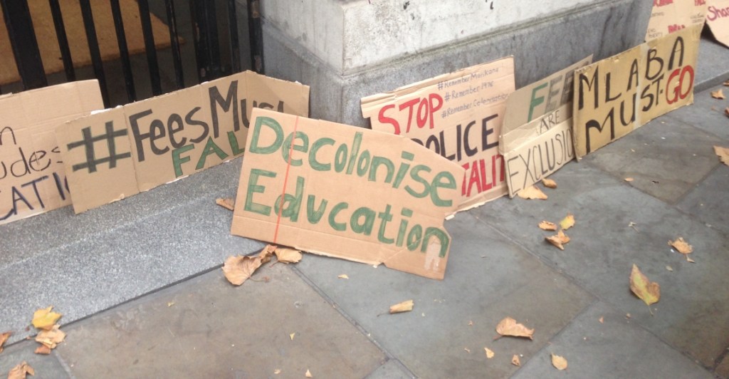 Various cardboard signs from a student protest, some calling for decolonisation.