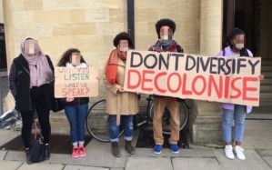 Students at a protest at the University of Glasgow holding signs that say 'Will you listen when we speak?' and 'Don't Diversify, Decolonise'.