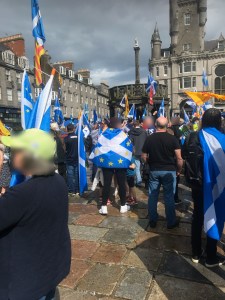 A supporter of Scottish independence is wrapped in a flag which blends the saltire and European stars at a pro-independence march in Aberdeen, August 2019.