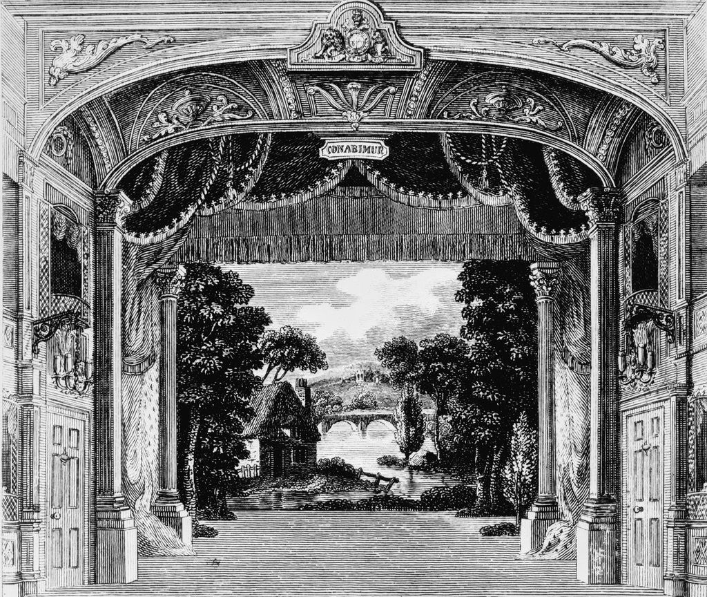 A black and white illustration of a theatre auditorium, focussing in on the proscenium arch. It appears to be an 18th century theatre with an idyllic set painted on the back wall of the theatre.