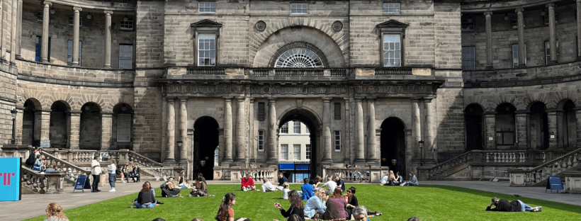 University students networking on the lawn at New College, University of Edinburgh