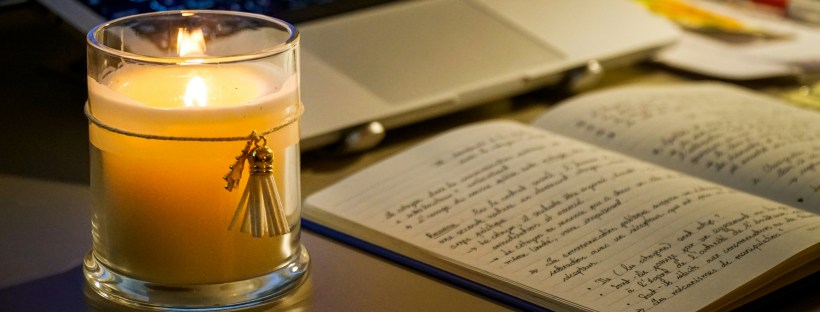 A cosy study desk with open books, handwritten notes, sticky notes, stationery and a laptop arranged for a study session.